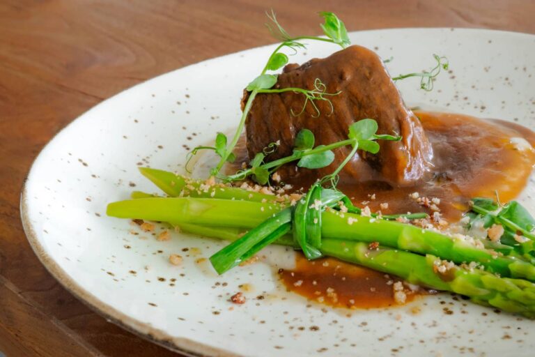 Five-hour slow-cooked beef short ribs in red wine reduction with asparagus at Klive Beach Club