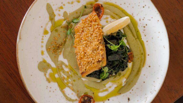 Grilled red snapper with quinoa crust, green pea purée, sautéed spinach, and lemon at Klive Beach Club Uluwatu